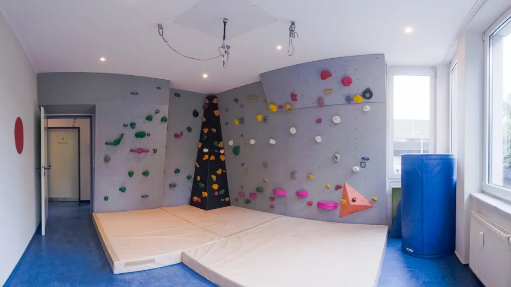 Bewegungsraum mit Kletterwand und Schaukelaufhängung